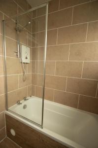 uma casa de banho com um chuveiro e uma banheira em The garden flat em Torquay