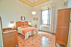 a bedroom with a bed with orange sheets and a window at Villa Bellavista - Tuscany panoramic view in Crespina