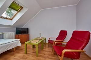 a room with two chairs and a table and a tv at Pokoje Nowakowscy in Łeba