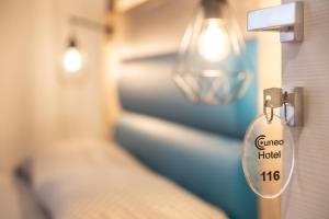 a tag on a door in a room with a bed at Cuneo Hotel in Cuneo