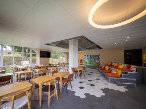 a restaurant with tables and chairs and a couch at Ibis Styles Bobigny Centre Préfecture in Bobigny