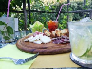 una tabla de cortar con queso y carne sobre una mesa en Le Petit Chateau, en Vezzi Portio