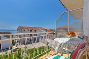 einen Balkon mit einem Tisch und Meerblick in der Unterkunft Apartments Jovic in Makarska