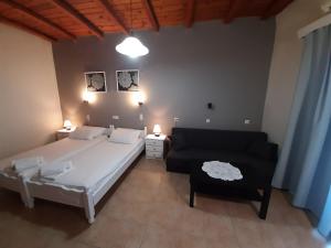 a bedroom with a large white bed and a couch at Agia Roumeli Hotel in Agia Roumeli