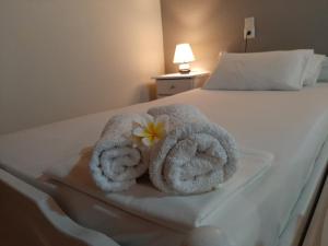 a hotel room with towels and a flower on a bed at Agia Roumeli Hotel in Agia Roumeli