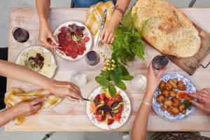 un grupo de personas sentadas alrededor de una mesa con comida en La Belle Folie, en Ploemel