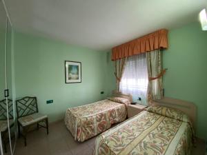 1 dormitorio con 2 camas y ventana en Salou, zona cerca de paseo Jaime I, en Salou