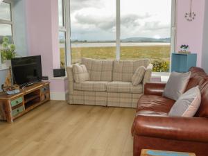 a living room with a couch and a television at Driftwood in Milnthorpe