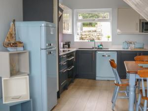 a kitchen with a blue refrigerator and a table at Driftwood in Milnthorpe