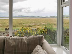 a couch sitting in front of a window with a view at Driftwood in Milnthorpe