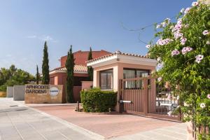 una pequeña casa con una puerta frente a un edificio en Resitour - Aphrodite Gardens, en Pafos