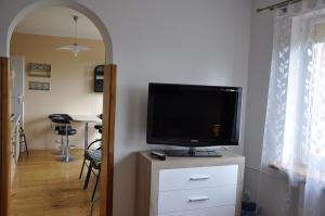 a flat screen tv sitting on a dresser in a living room at Willa Zuza in Kołobrzeg