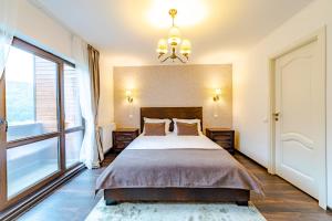 a bedroom with a large bed and a large window at Yael Luxury Apartments 3 in Buşteni