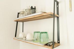 a shelf with glasses and other items on it at CityApartment K1 KLIMATISIERT in Friedrichshafen