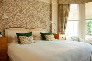 a bedroom with a large white bed with green pillows at Ravenhill House in Belfast