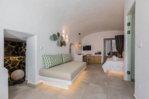 un soggiorno con letto e camino di Eternity Suites Santorini a Firà
