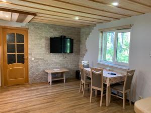 a dining room with a table and a tv on the wall at Kammelja Puhkemajad in Kuru