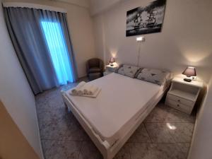 a bedroom with a large white bed and a window at Agia Roumeli Hotel in Agia Roumeli