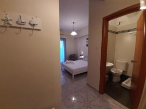 a bedroom with a bed and a bathroom with a toilet at Agia Roumeli Hotel in Agia Roumeli