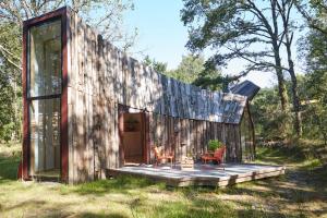 a small wooden cabin with two chairs and a table at La Belle Folie in Ploemel