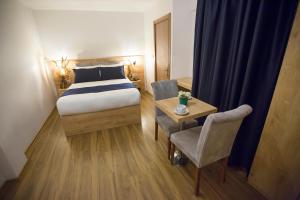a bedroom with a bed and a table with a chair at Golden Street Hotel in Istanbul