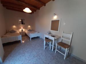 a bedroom with two beds and a desk and a mirror at Agia Roumeli Hotel in Agia Roumeli