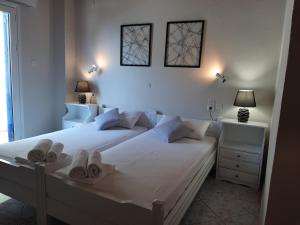 a bedroom with a white bed with towels on it at Agia Roumeli Hotel in Agia Roumeli