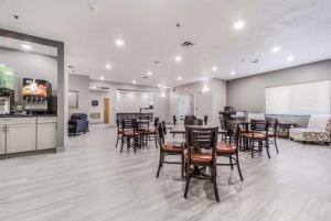 uma sala de jantar com mesas e cadeiras e uma cozinha em Quality Inn & Suites West Omaha - NE Linclon em Omaha