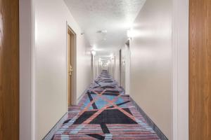 a hallway leading to a room with a blue floor at Quality Inn & Suites West Omaha - NE Linclon in Omaha
