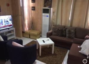a living room with a couch and a tv at IRWAN FAIZ GUEST & HOMESTAY in Kampung Gita