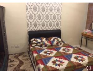 a bedroom with a bed with a quilt on it at IRWAN FAIZ GUEST & HOMESTAY in Kampung Gita