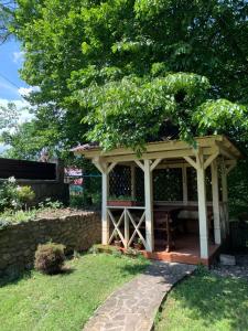 a gazebo in a yard with a stone wall at Вишиванка in Sheshory