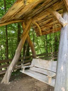 a swing seat in a wooden structure in the woods at Вишиванка in Sheshory