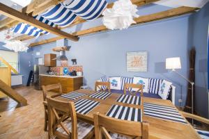 a dining room with a wooden table and chairs at Villa Mare Apartamenty in Grzybowo