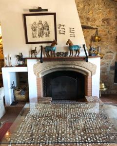 a fireplace with horse figurines on top of it at Apartamentos Rurales La Macera **** in Valencia de Alcántara