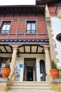 un bâtiment avec des plantes en pot à l'avant dans l'établissement Hotel Neguri, à Getxo