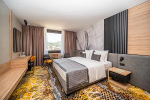 a hotel room with a bed and a desk at Hotel Holiday in Sarajevo