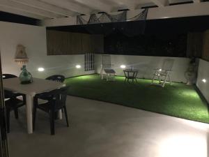 サンタ・マリア・デル・フォカッロにあるCasa Vacanza Della Malva 14のテーブルと椅子、緑の芝生のある部屋