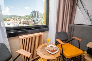 a room with a table with a drink and a window at Hotel Holiday in Sarajevo