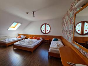 a room with two beds and two windows at István Parkhotel és Gasztrofarm in Sormás