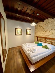 2 camas en una habitación con una pared de ladrillo en István Parkhotel és Gasztrofarm en Sormás