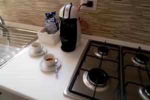 a kitchen counter with a stove and two cups of coffee at Barbarossa in Siena
