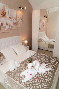 two swans are sitting on a bed in front of a mirror at Barbarossa in Siena