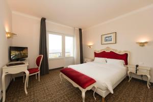 トロワ・エピにあるAlexain Hotel Restaurant & Wellness - Colmar Ouestのベッドとテレビが備わるホテルルームです。