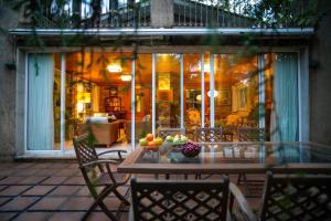 patio con tavolo e sedie sotto il portico di O Casal das Árbores a Santiago de Compostela