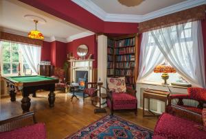 a living room with a pool table and a fireplace at Ardwyn House in Llanwrtyd Wells