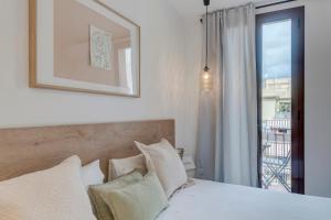 sypialnia z łóżkiem i oknem z widokiem w obiekcie Happy Apartments w Barcelonie