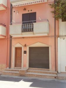 a building with two garage doors and a balcony at Appartamento moderno in Le Castella