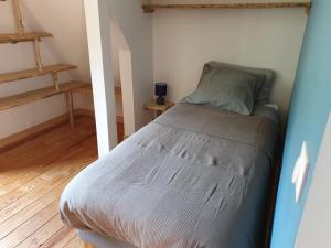 una piccola camera con un letto in una stanza di LESPONNE Gîte Il granaio di Lesponne a Lesponne