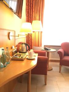 a hotel room with a table with a tea kettle on it at Altes Gasthaus Kuhr - Hotel & Restaurant in Papenburg